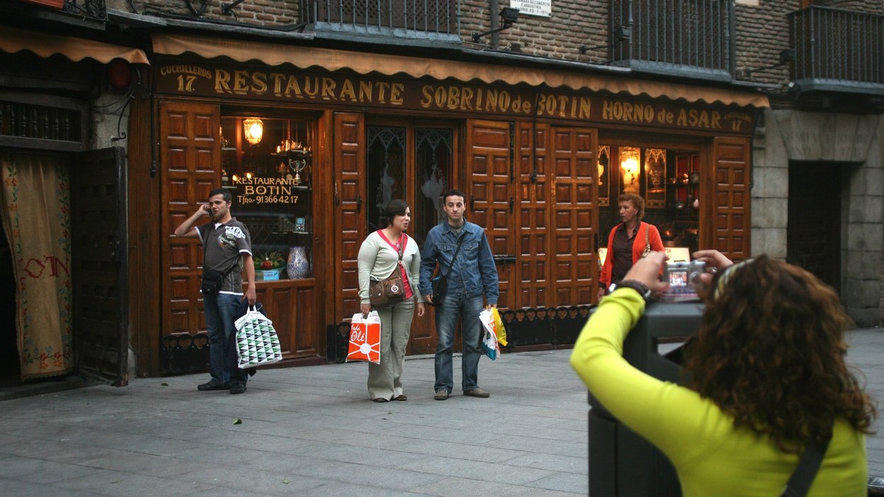 A világ legrégebbi étterme előtt fotózkodnak turisták.
