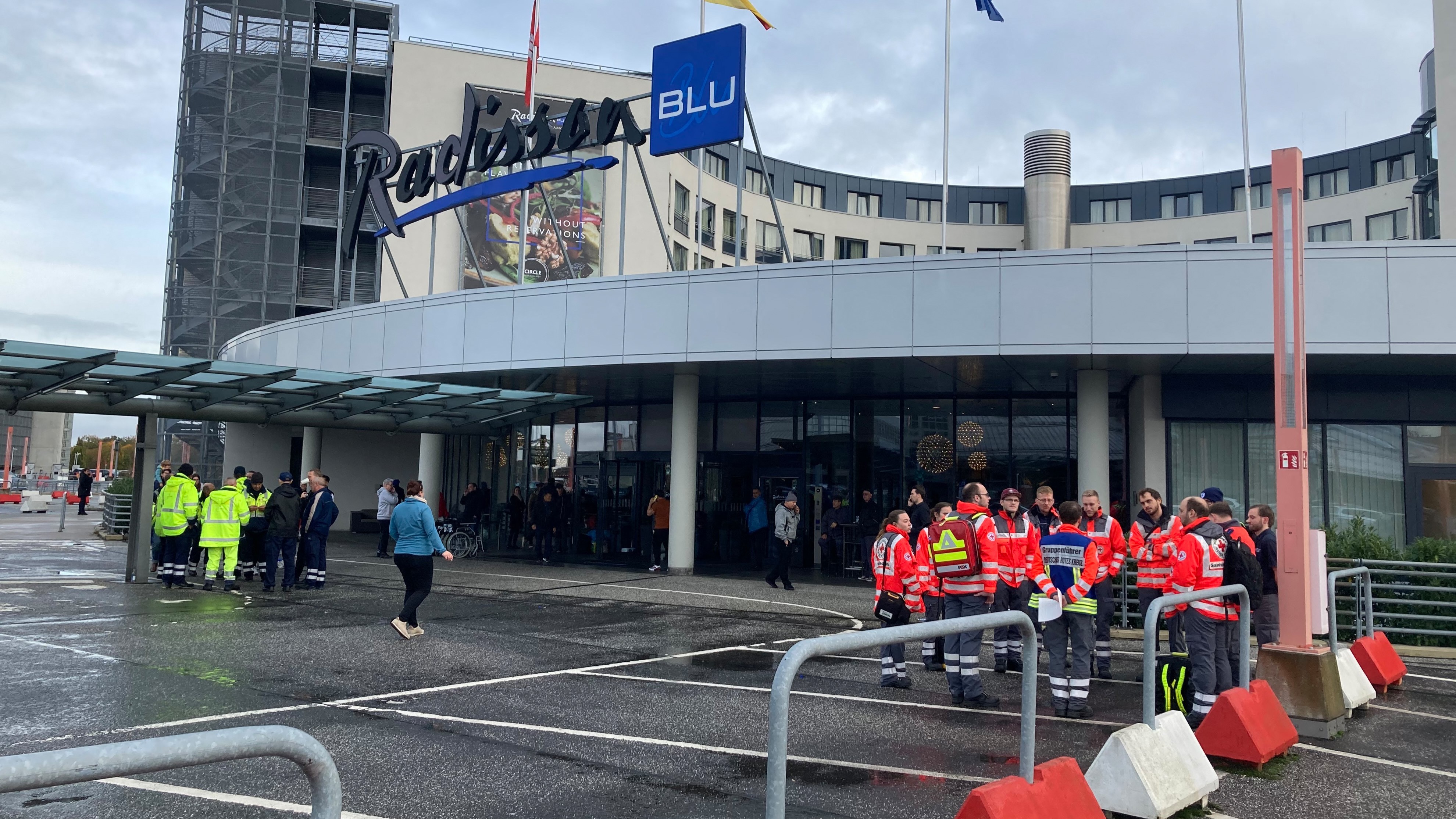 A Vöröskereszt segélyszolgálata a Radisson Blu Hotel előtt áll, ahol a hamburgi repülőtérről érkező utasokat szállásolják el