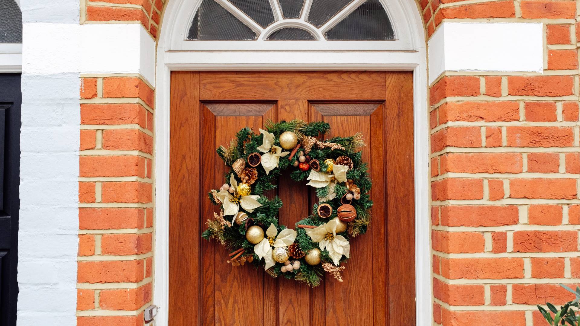 Téglás ház barna ajtaján karácsonyi dísz.