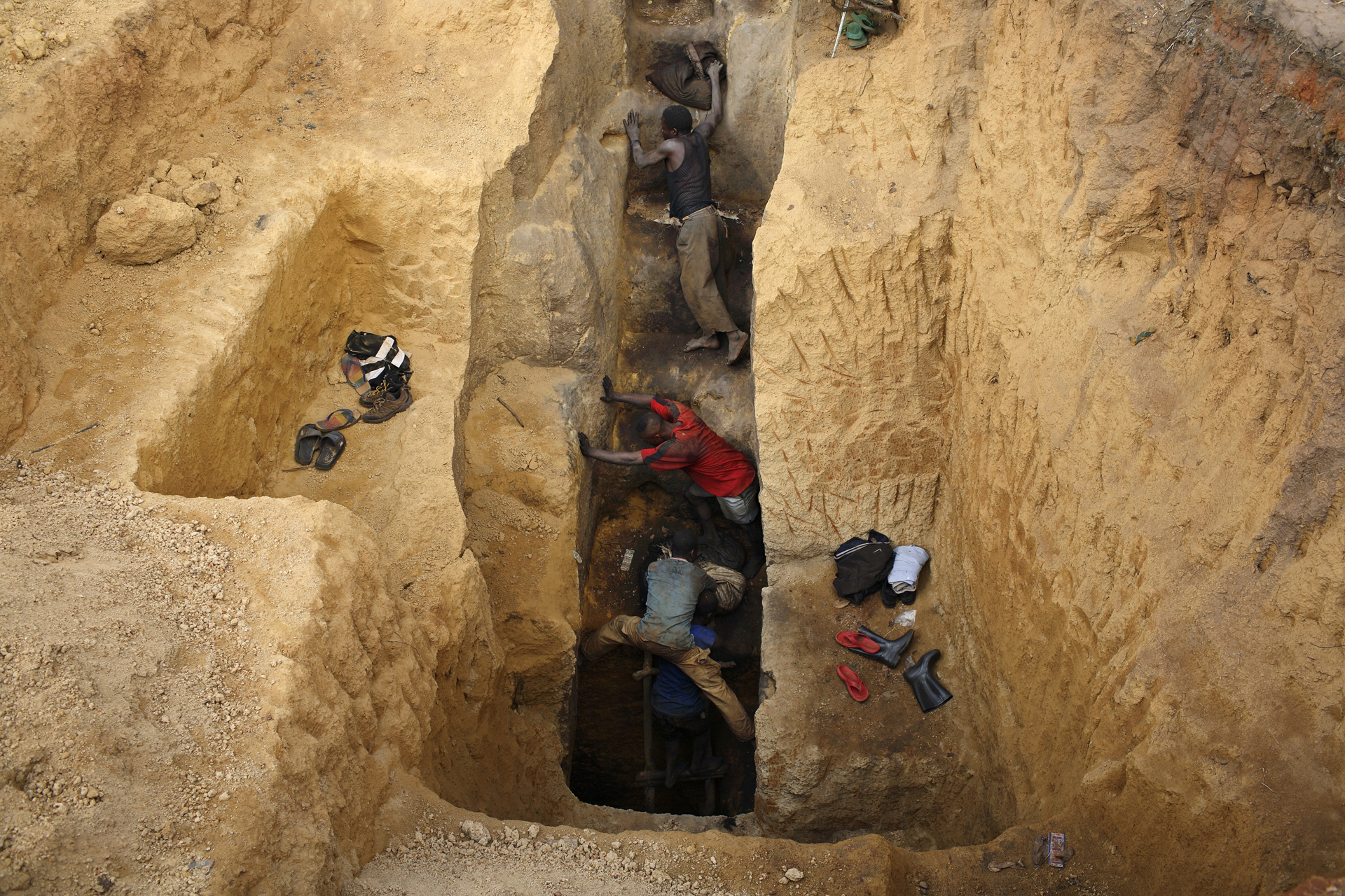 Kobalt bányászok másznak fel egy gödörből