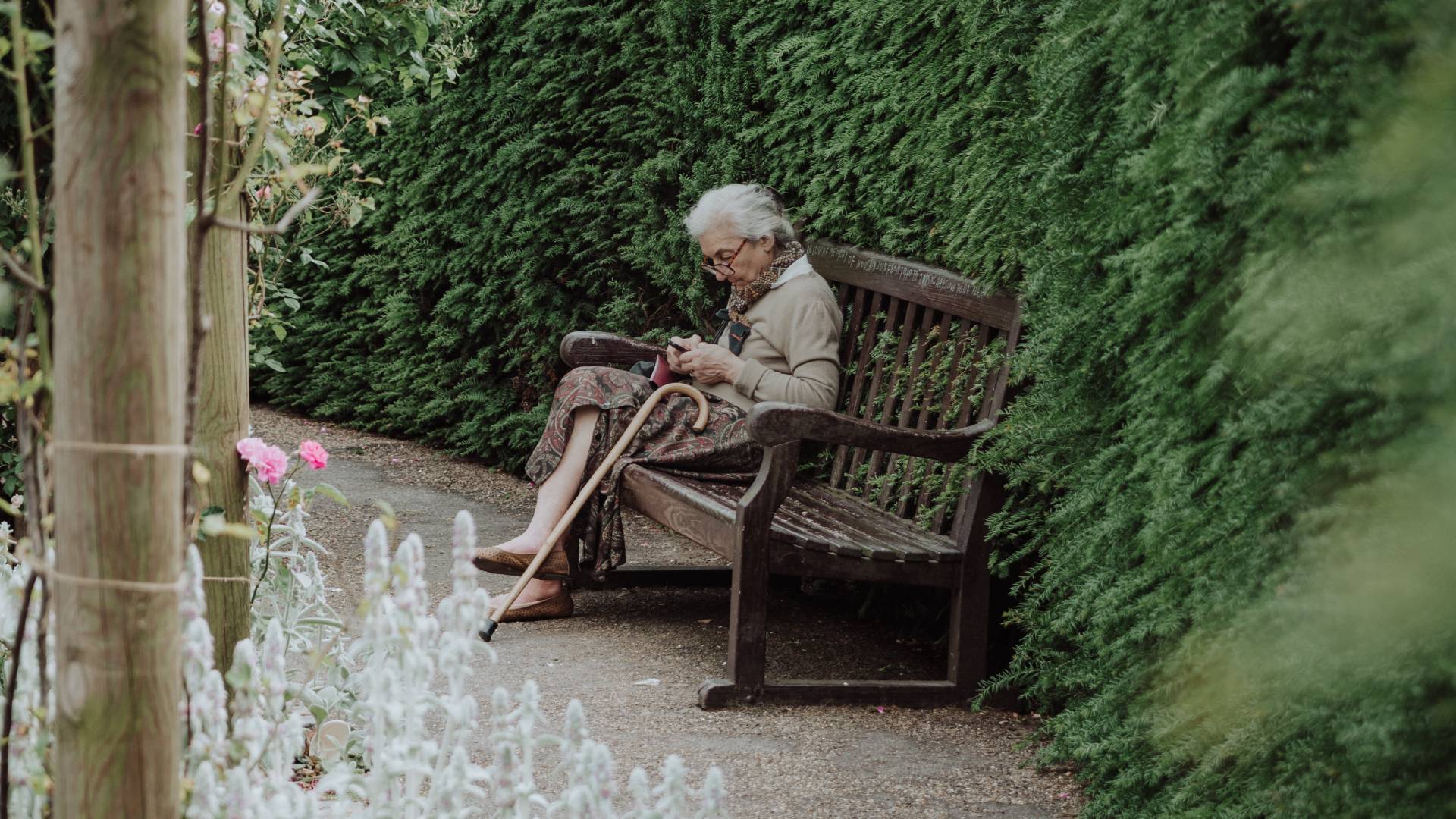 Kerti padon üldögélő idős nő.