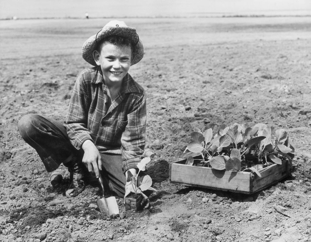 Egy kisfiú flanelingben kertészkedik, a kép az 1940-es években készült.