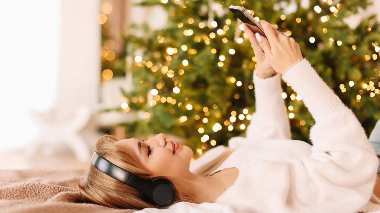 Zenét hallagató lány, a háttérben karácsonyfa.