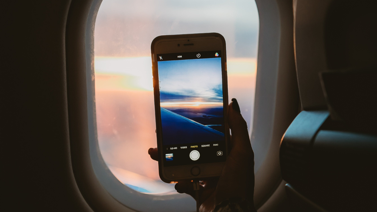 Egy nő a repülőgépből fényképezi az eget