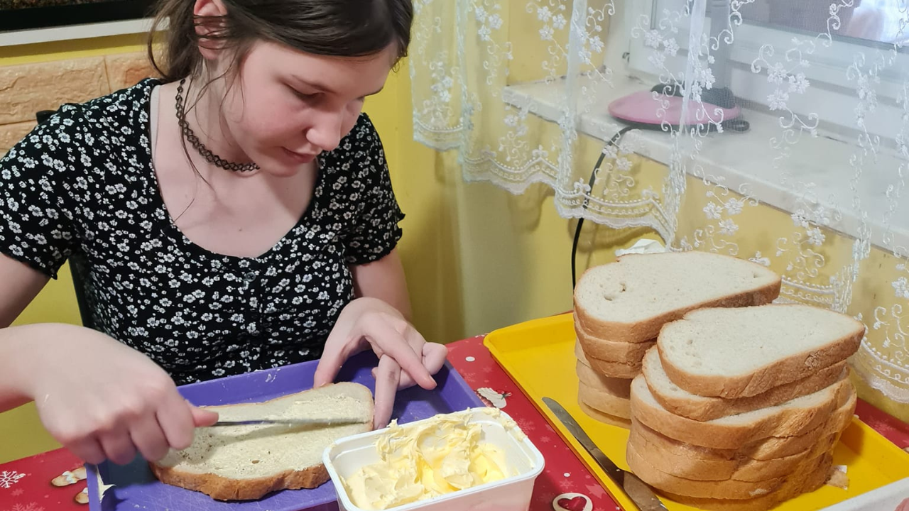 A 14 éves kislány szendvicset készít a rászorulóknak