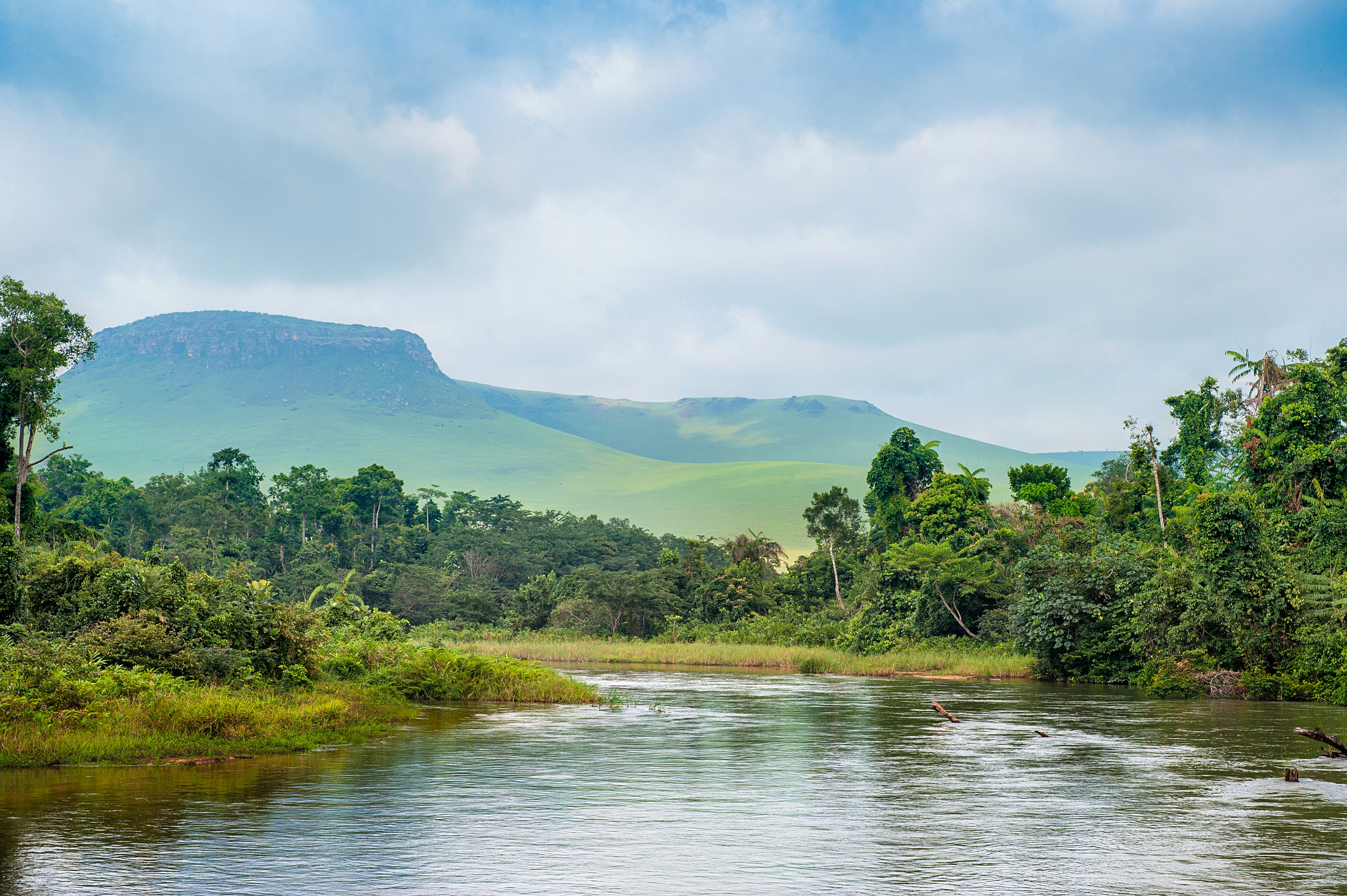 A felhős ég alatt, a dombokon és hegyeken keresztül egy kis folyó Kongó dzsungelében halad (Fotó: Getty Images)