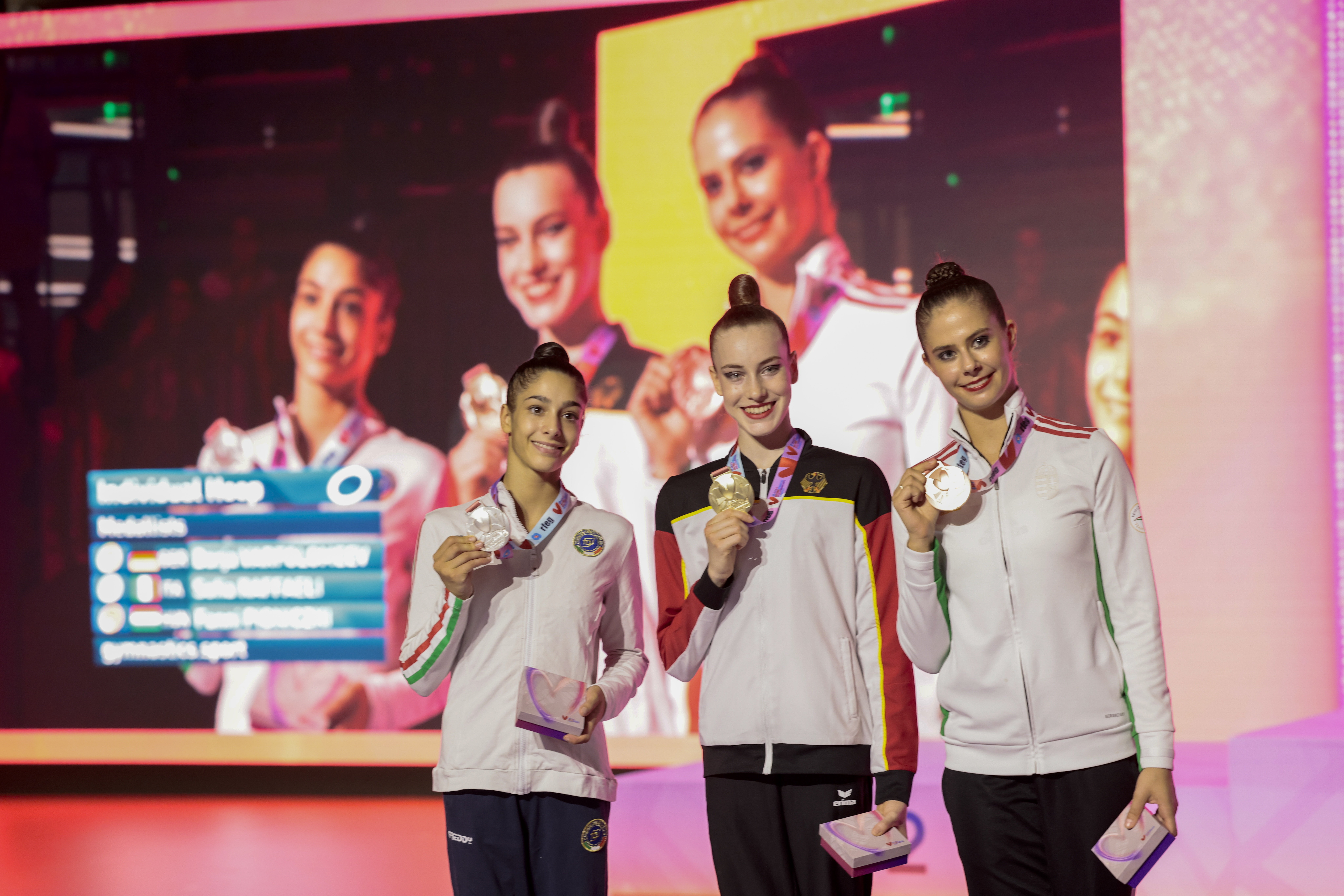 Az ezüstérmes olasz Sofia Raffaeli, az aranyérmes német Darja Varfolomeev és a bronzérmes Pigniczki Fanni (b-j) az olimpiai kvalifikációs ritmikusgimnasztika-világbajnokság karikaversenyének eredményhirdetésén Valenciában 2023. augusztus 23-án. (Fotó: MTI/EPA/EFE/Ana Escobar)