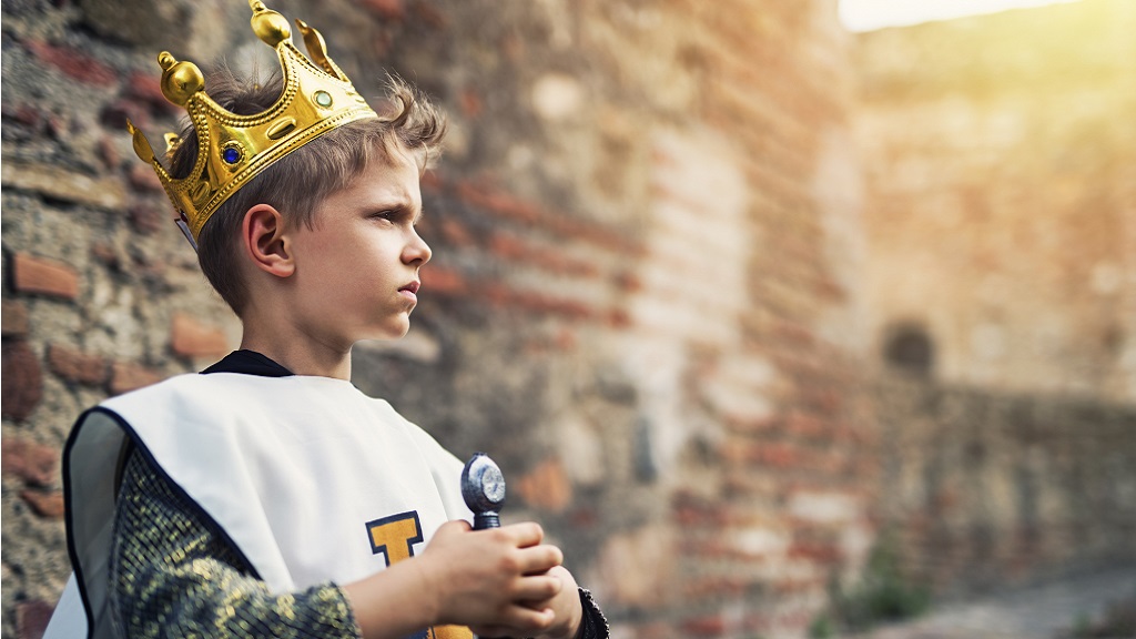 Kisfiú koronával a fején, királynak öltözve