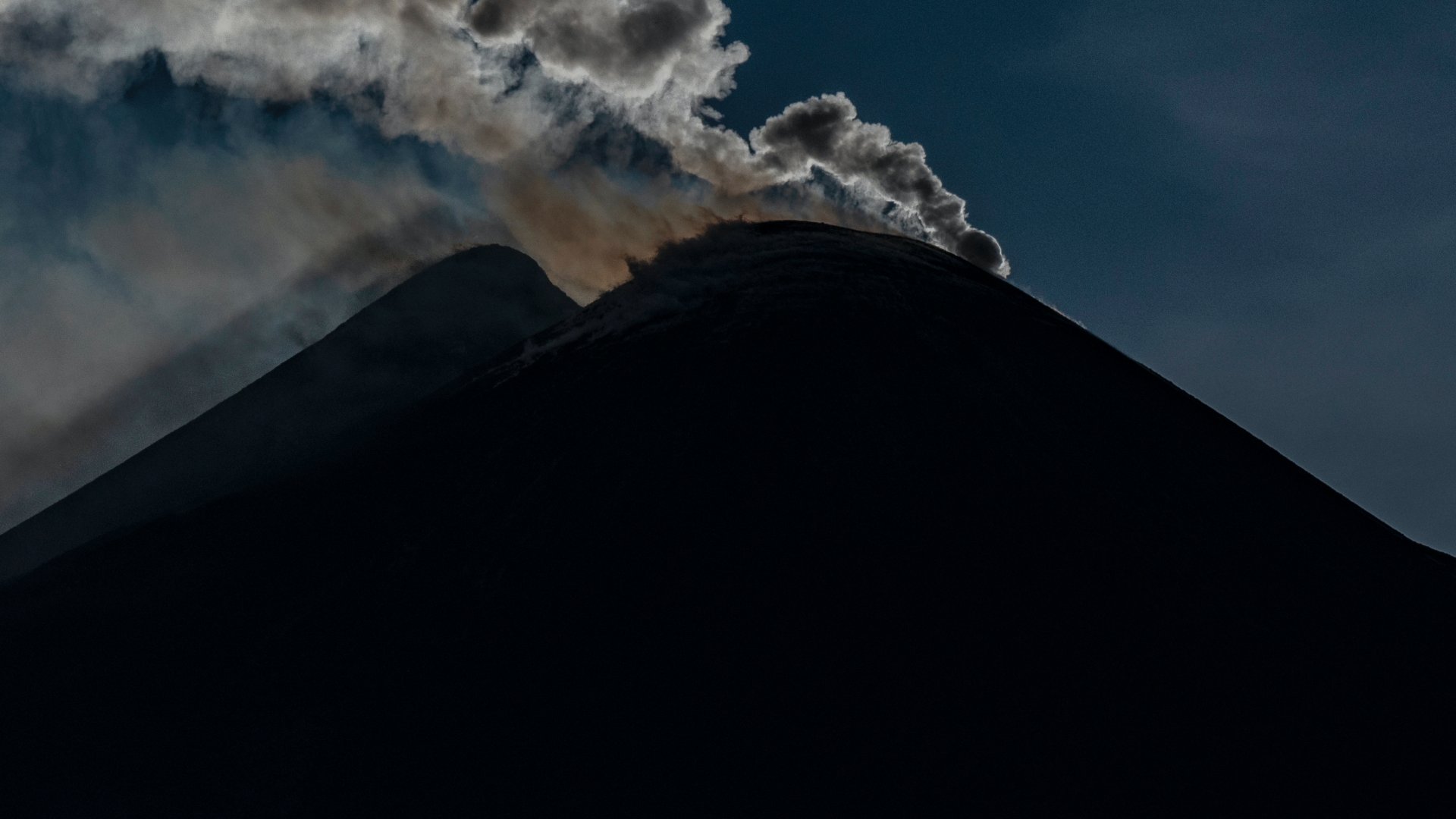Az Etna vulkán délkeleti krátere naplementekor, amint gőzgyűrűket bocsát ki 2024. április 6-án az olaszországi Cataniában