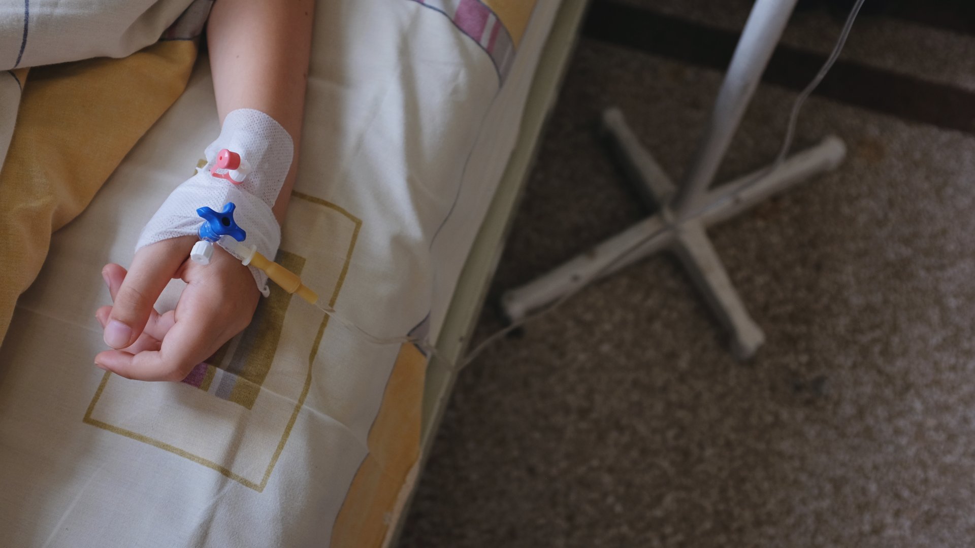 Infúzió egy kórházi ágyon fekvő gyerek kezében