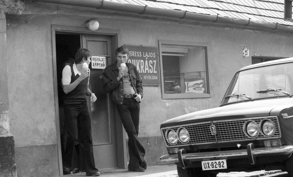 Életérzés. 1975, a cukrászda ajtajában Verrasztó Zoltán és Hargitay András úszó. Bokor utca 27. / Kép forrása: Fortepan, adományozó: Urbán Tamás