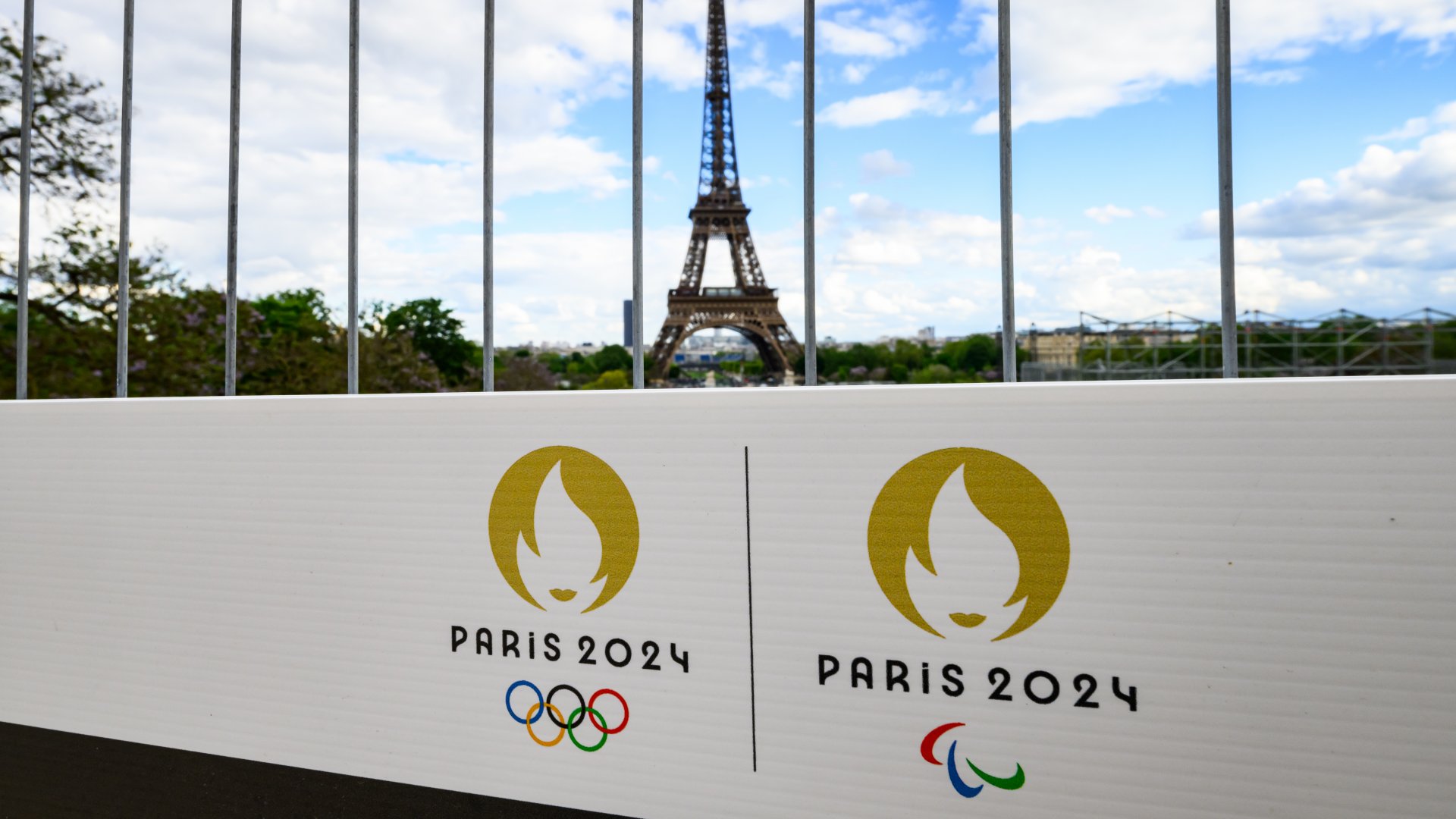 A 2024-es párizsi olimpia logója az Eiffel-torony előtti építési kerítésen