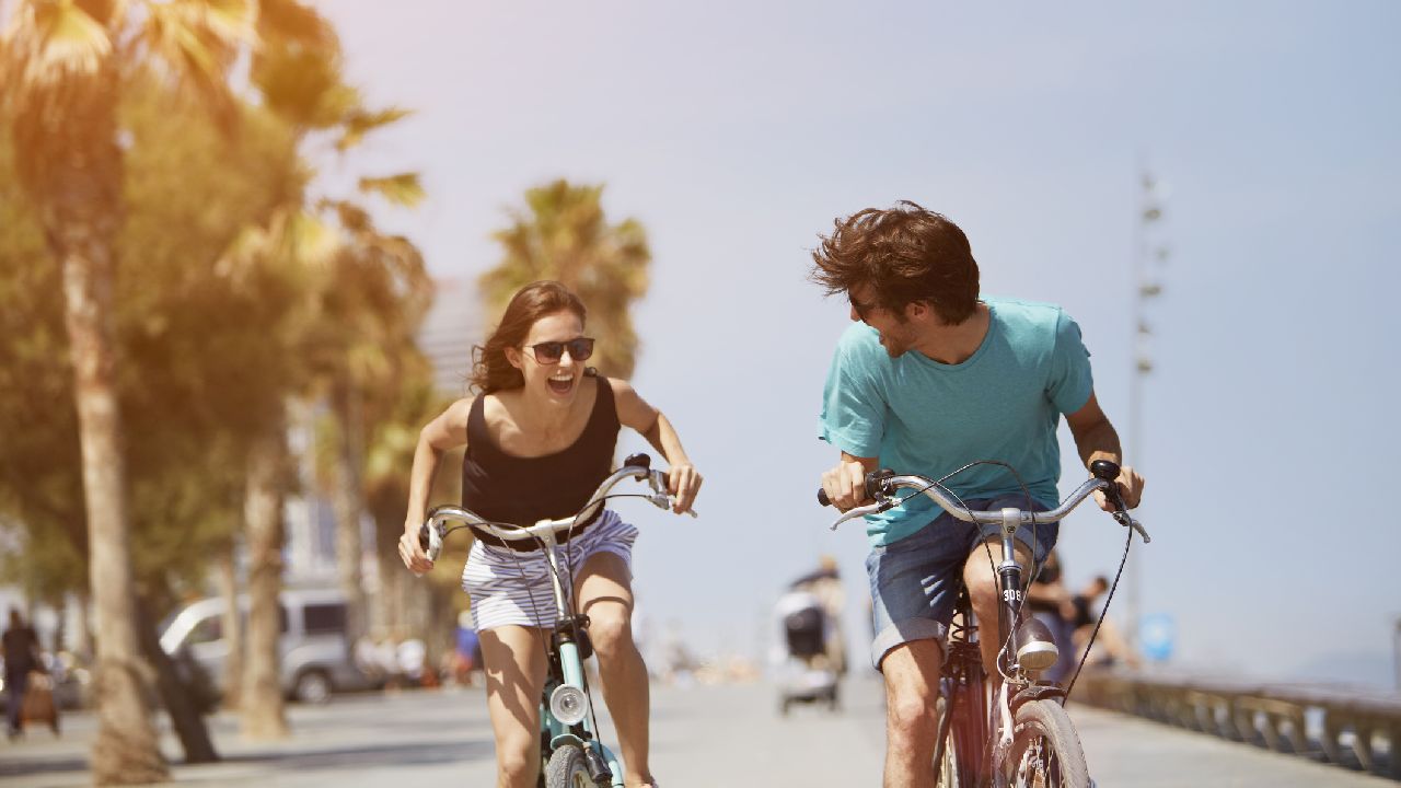 Fiú és lány biciklizik nevetve