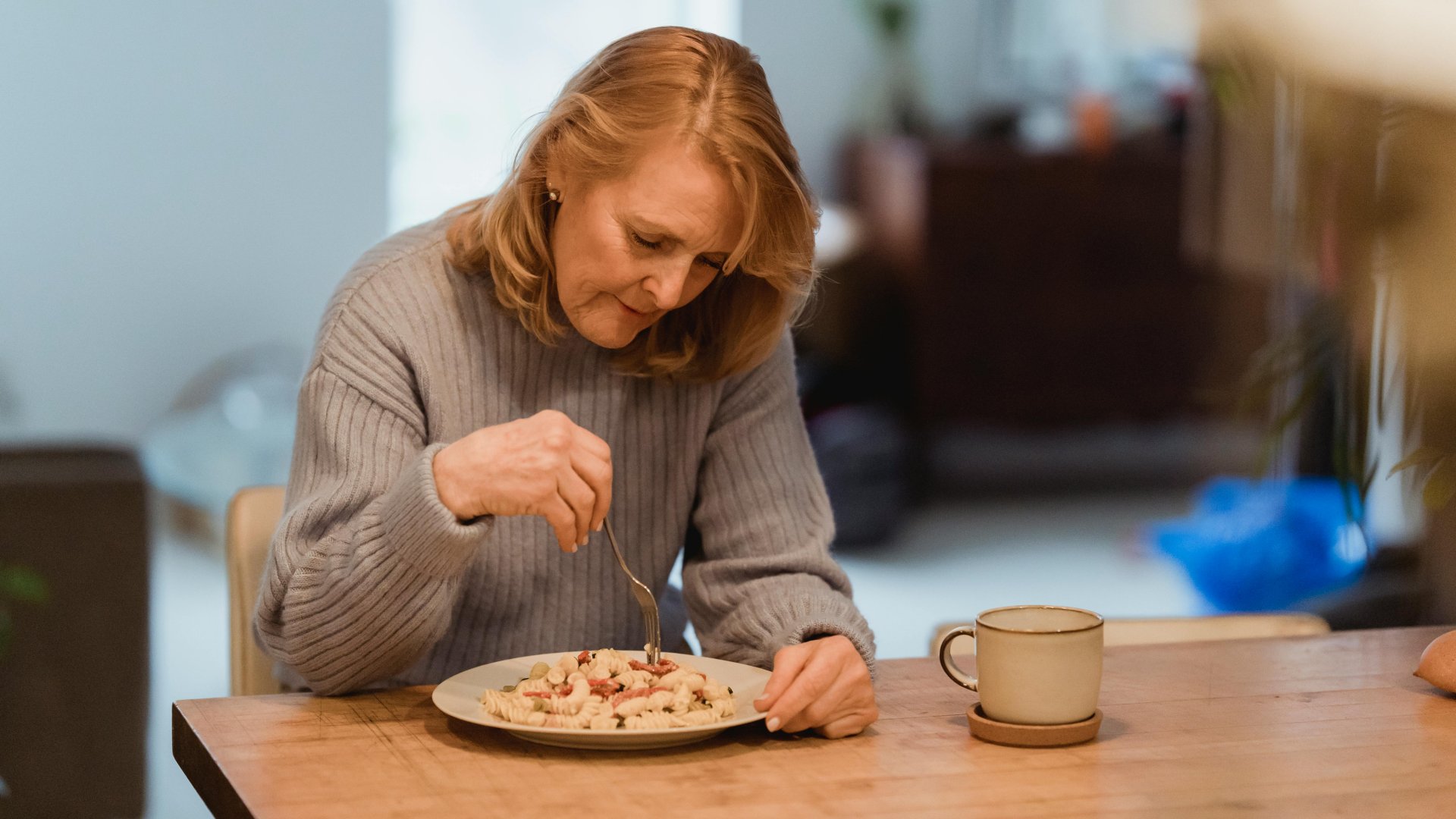 Egy nő egyedül eszik tésztát otthon