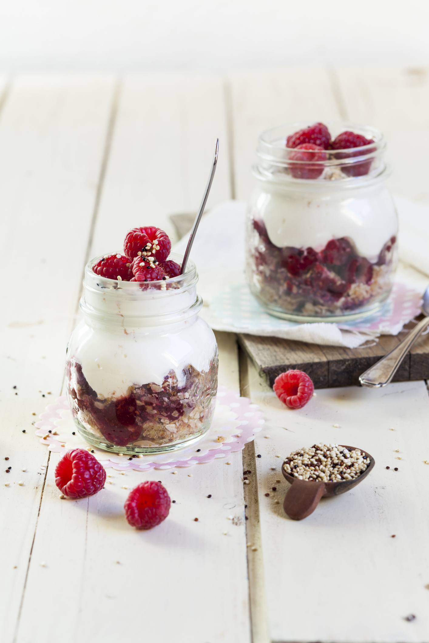 Főtt quinoa rétegzett pohárdesszert egyik rétegeként joghurt és gyümölcsök mellett.