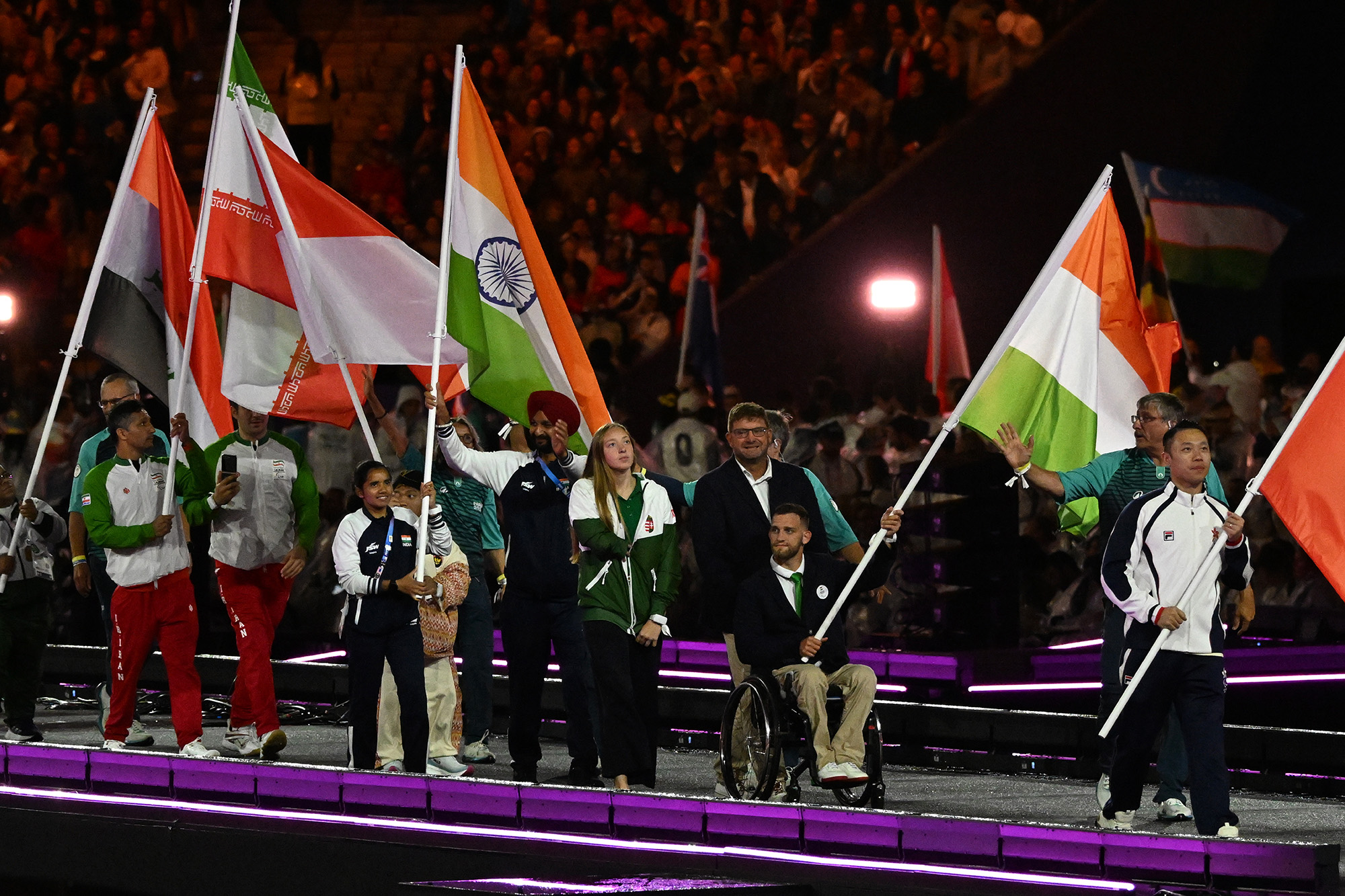 Konkoly Zsófia úszó és Kiss Péter Pál kajakozó (középen) viszi a magyar zászlót a 2024-es párizsi nyári paralimpiai játékok záróünnepségén a Stade de France-ban 2024. szeptember 8-án. Fotó: MTI/Koszticsák Szilárd