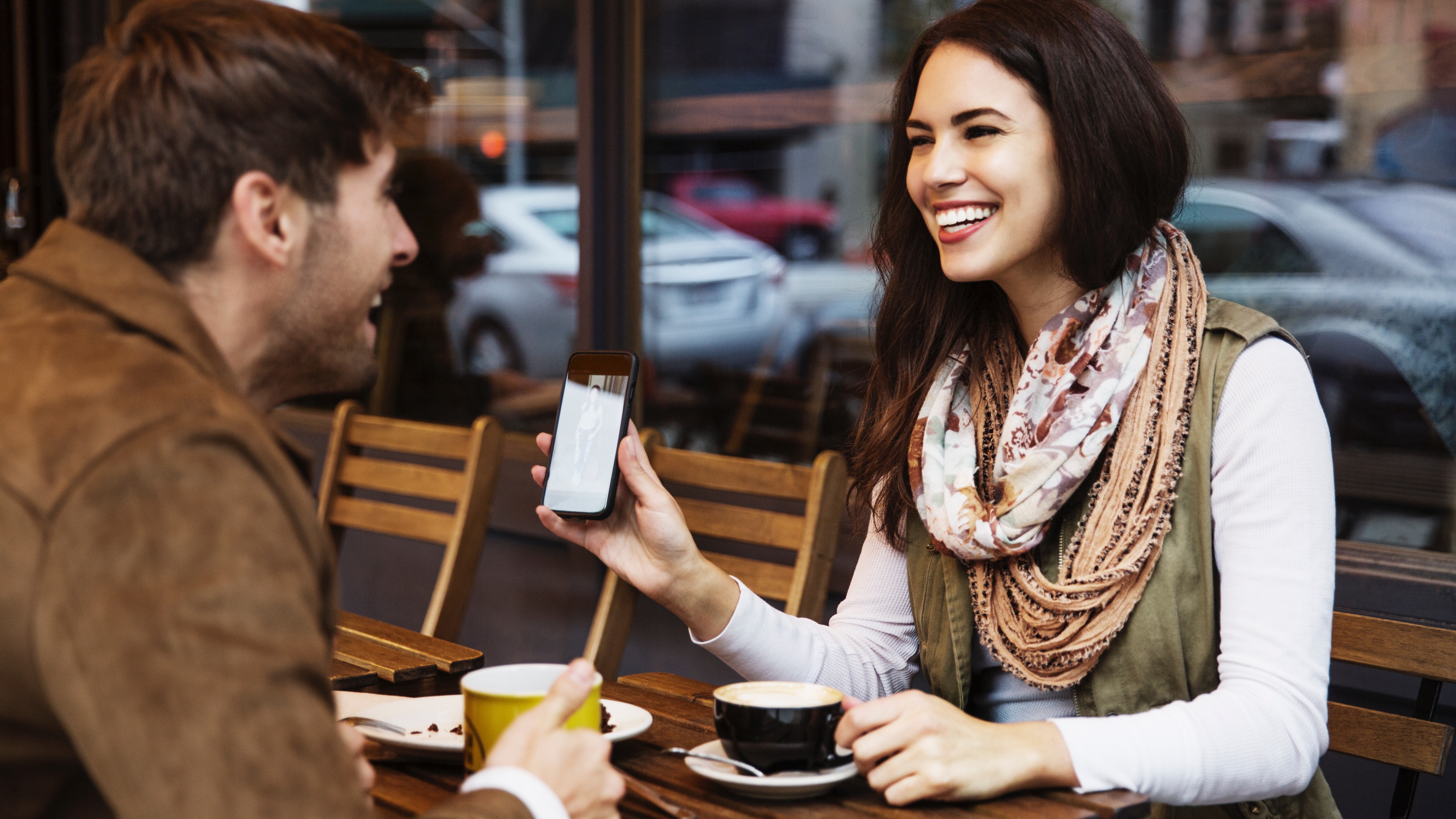 Egy nő a telefonján mutat valamit egy randin