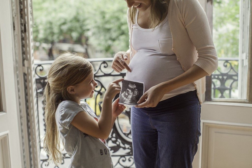 Kismama és kislánya egy ultrahang képpel