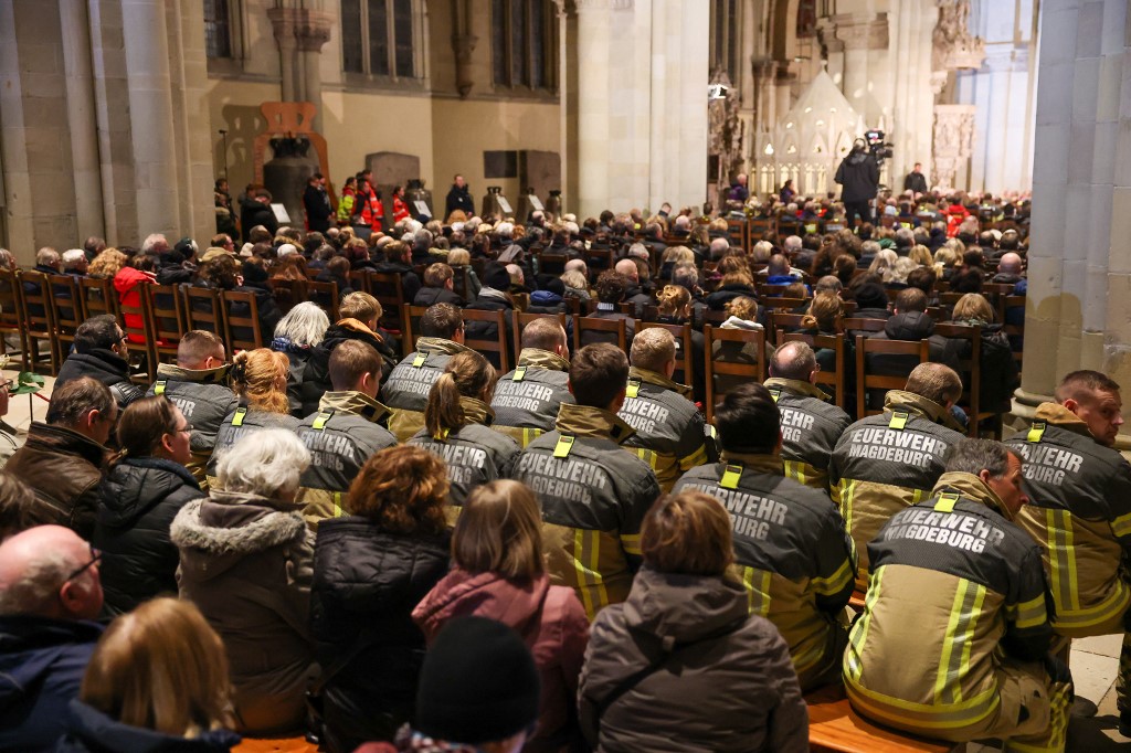 űzoltók ülnek a megemlékezésen a dómban. Előző este egy autós belehajtott egy embercsoportba a magdeburgi karácsonyi vásáron.